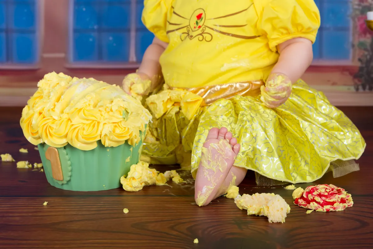 Meisje in geel Belle-jurkje smasht haar gele taart voor het kasteeldecor, cake smash fotoshoot Zoetermeer