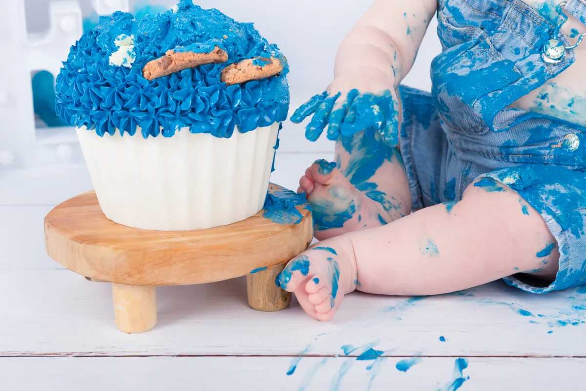 Kindje in spijkerbroek bij een blauwe Koekiemonster taart met koekjes tijdens de cake smash fotoshoot in Zoetermeer