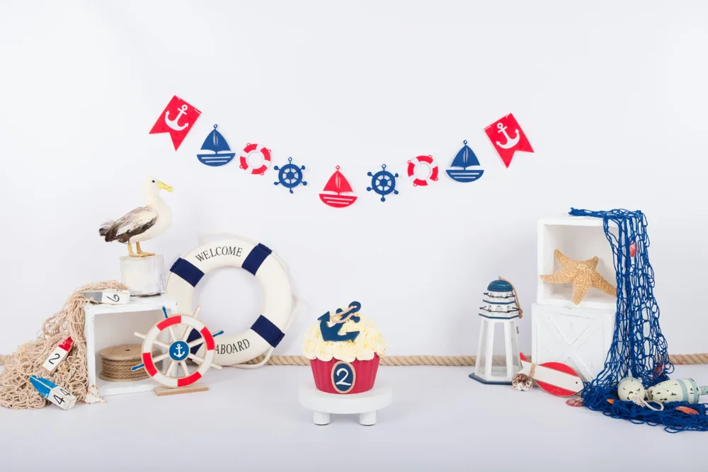 Maritiem cake smash decor met reddingsboei, scheepsroer, vissersnet en vlaggenslinger, fotostudio Zoetermeer