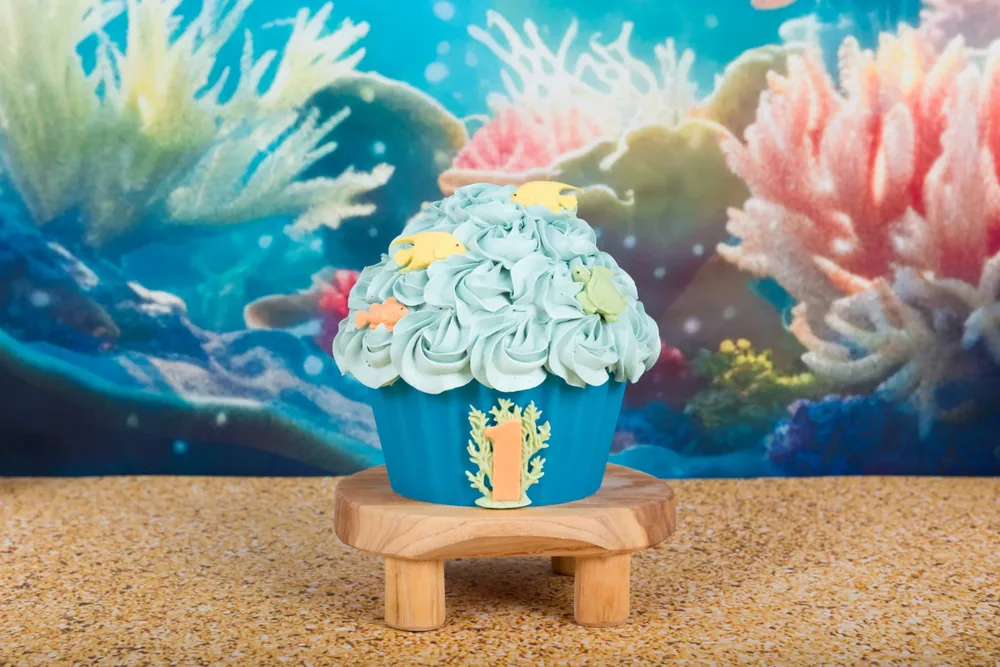 Cake smash taart met zeegroene rozetten en visjes op een blauwe wikkel met koraal en het cijfer 1, Zoetermeer
