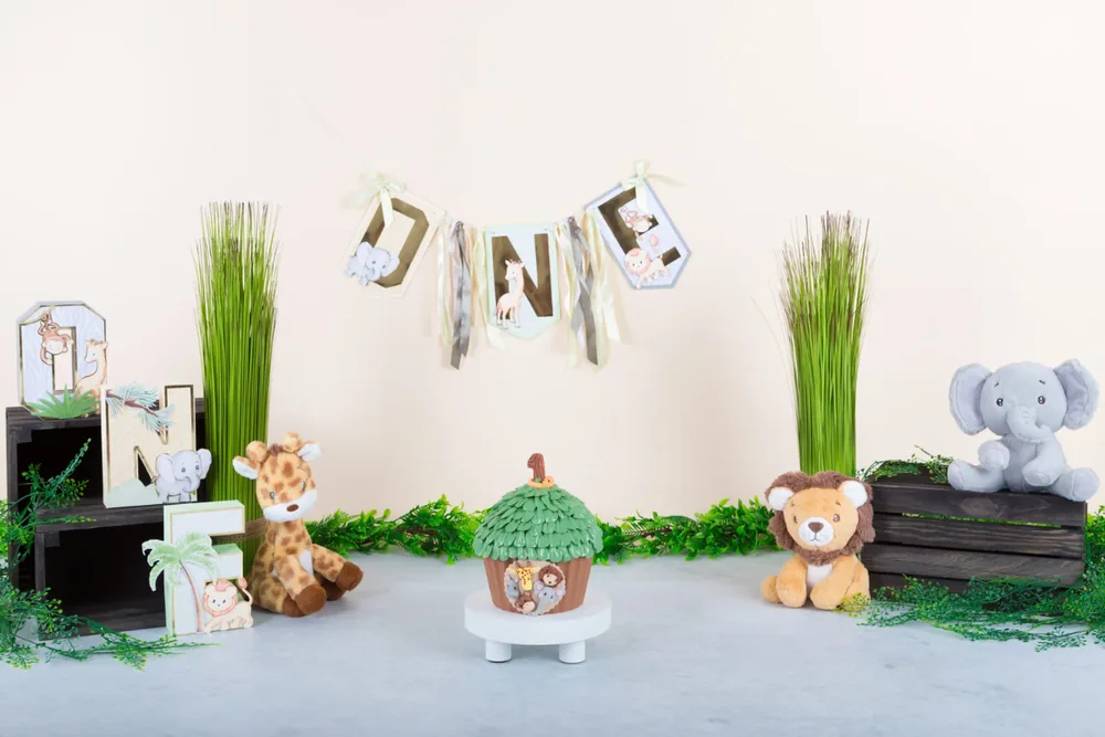 Safari cake smash decor met giraf, leeuw en olifant tussen het gras onder een ONE-slinger, fotostudio Zoetermeer