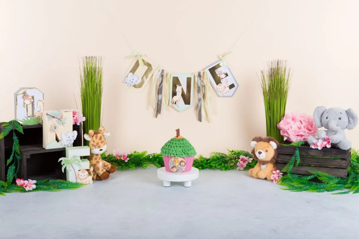 Zacht jungle baby cake smash decor met giraf, olifant en leeuw tussen varens, fotostudio Zoetermeer