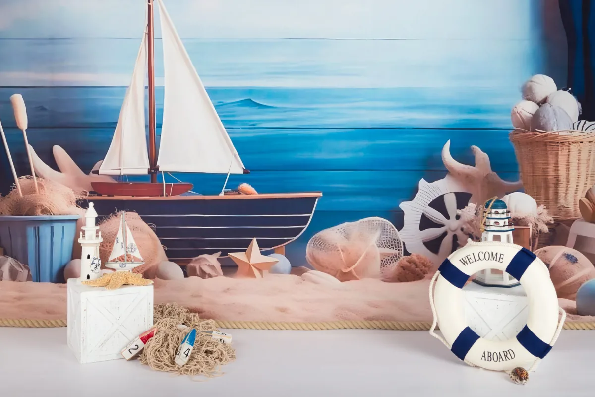 Maritiem cake smash decor met zeilboot, vuurtoren en reddingsboei op het strand, fotostudio Zoetermeer