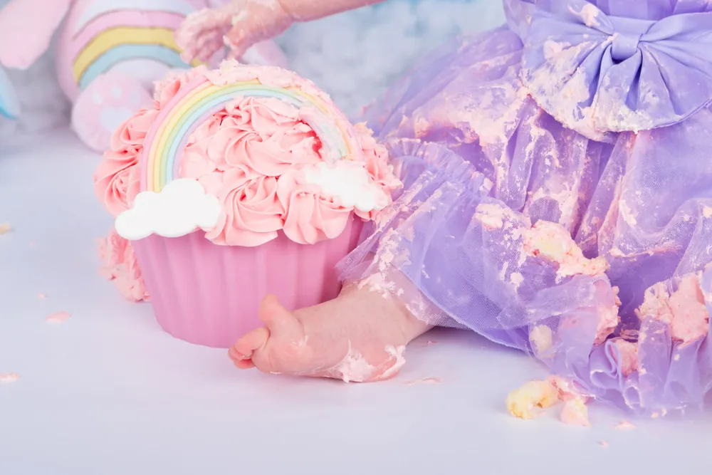 Kindje in lila tutu naast de omgevallen regenboogtaart van de Troetelbeertjes cake smash, fotostudio Zoetermeer