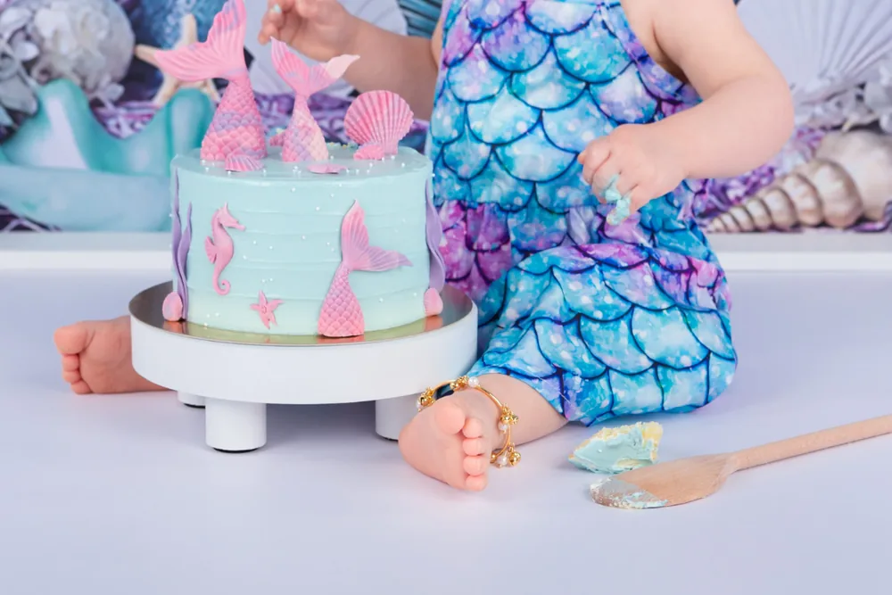 Kindje in zeemeerminjurkje met schubbenprint bij de zeemeermintaart, cakesmash fotoshoot Zoetermeer