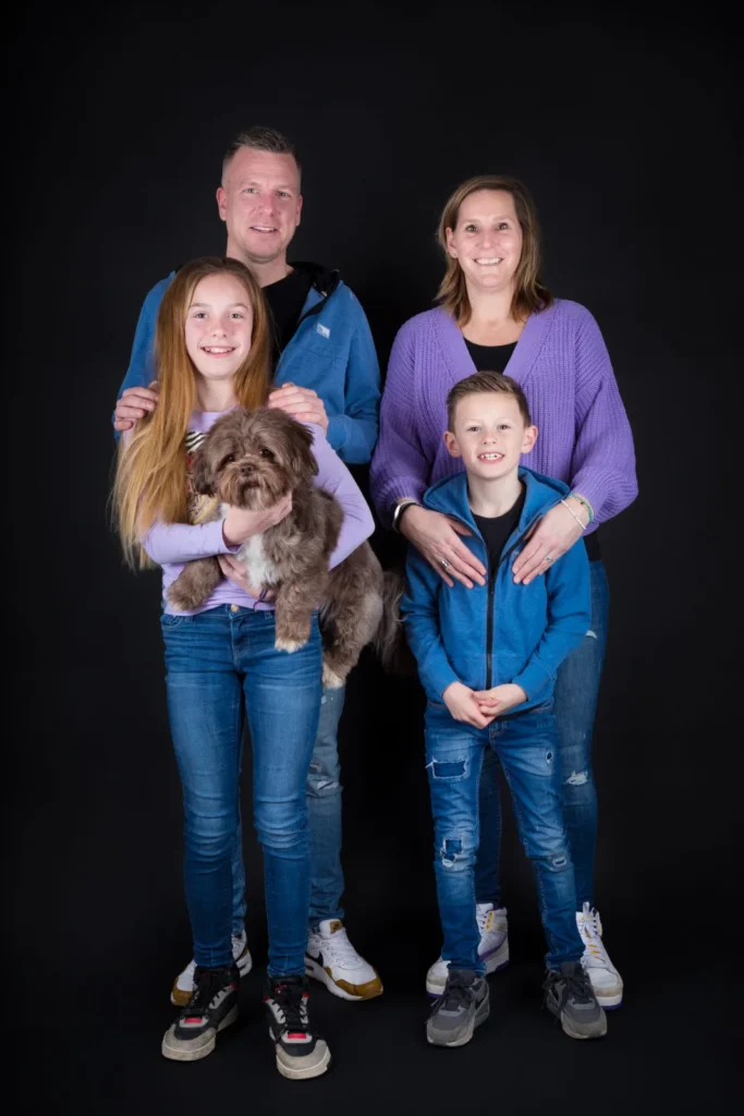Gezin met twee kinderen en hun hond tijdens een familie fotoshoot in de studio