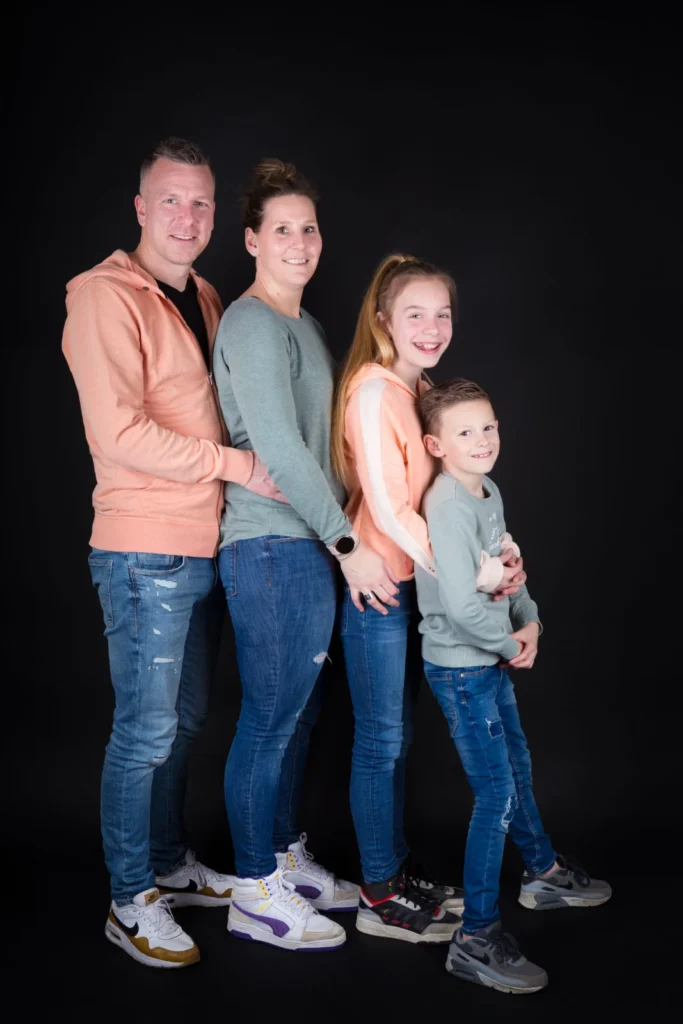 Gezin van vier op een rij voor een zwarte achtergrond in de studio