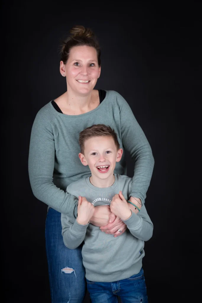 Moeder met haar zoon in haar armen tijdens een familie fotoshoot