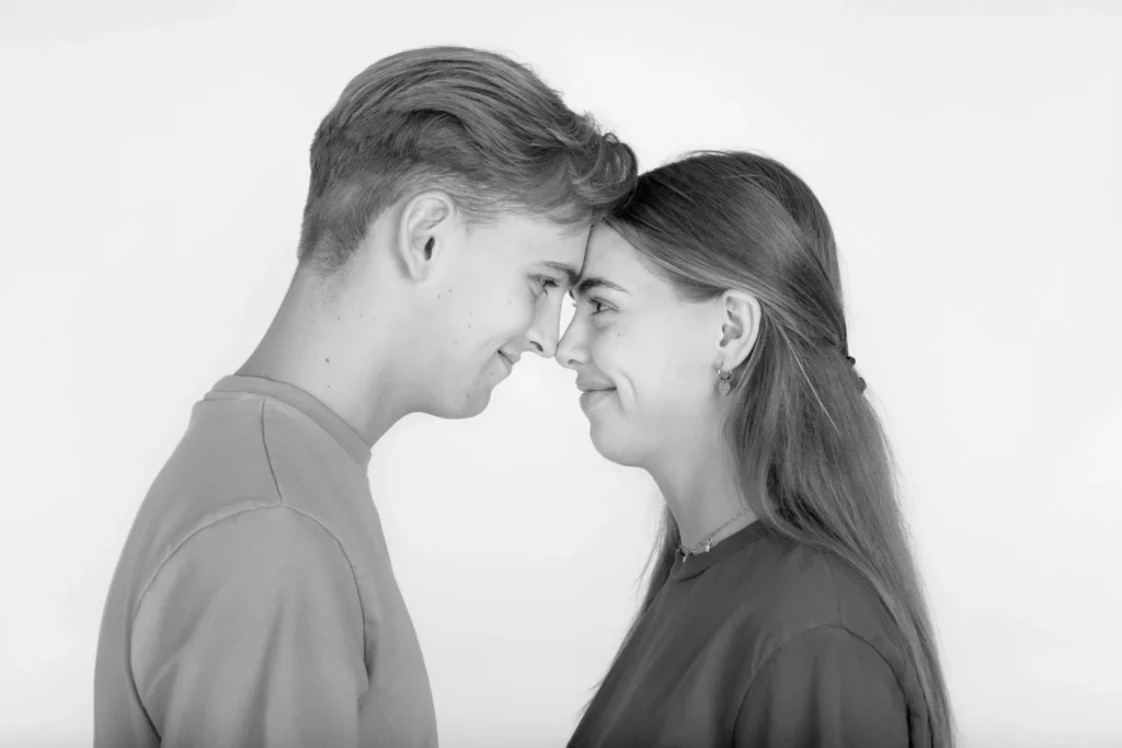 Zwart-witfoto van twee jongeren met hun voorhoofden tegen elkaar