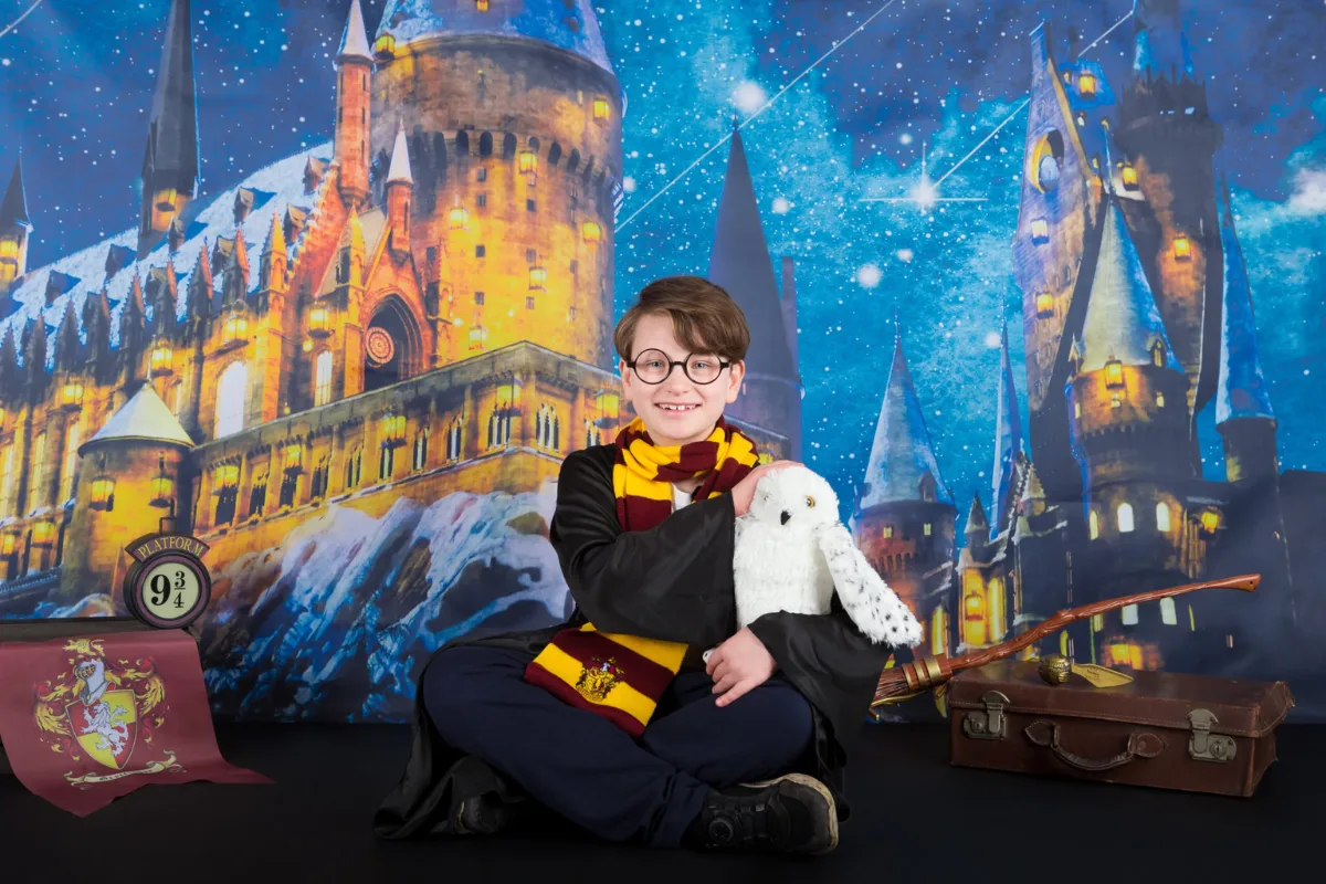 Jongen met Harry Potter-bril en sjaal voor een Hogwarts decor